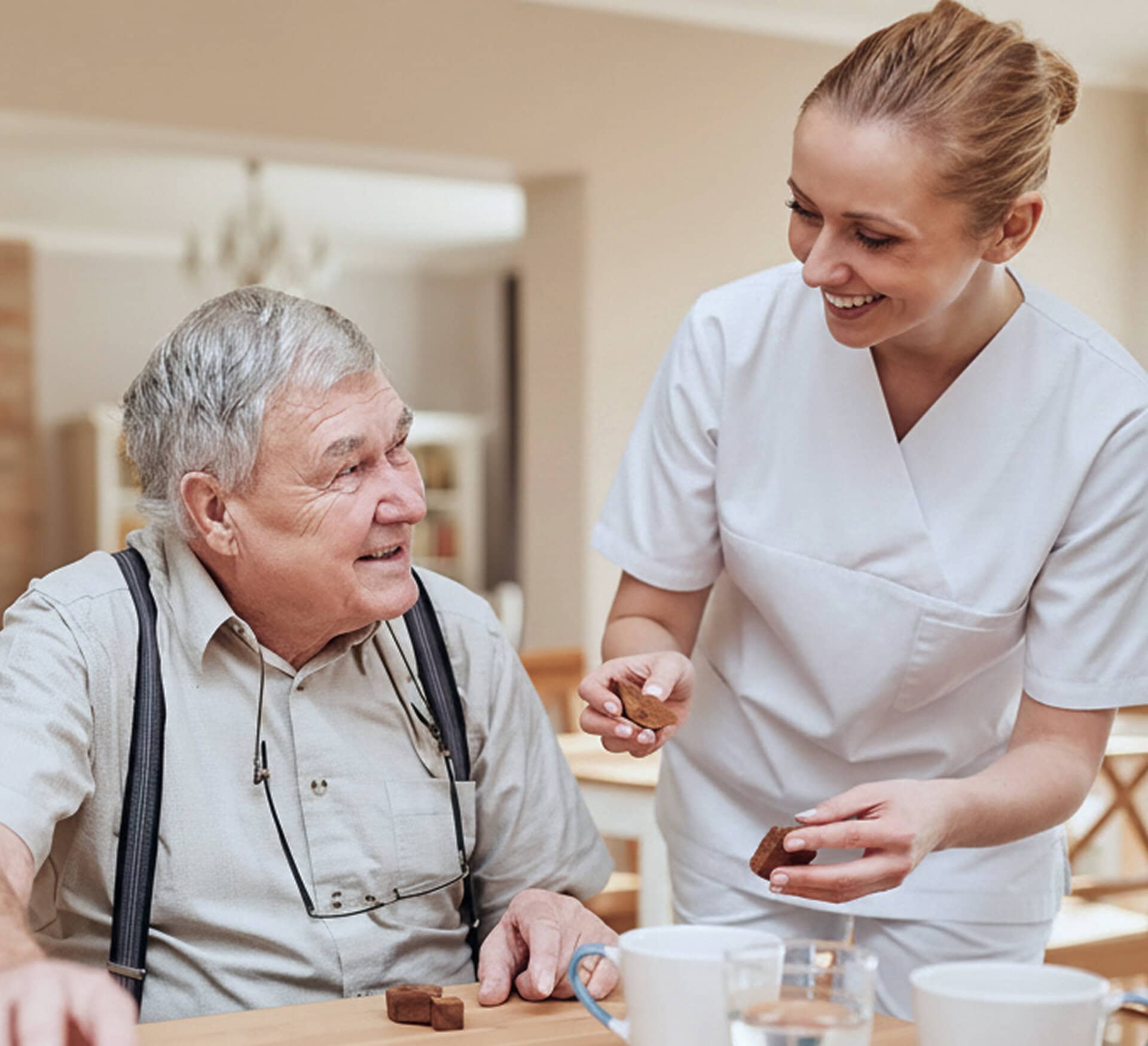 Elderly man receiving compassionate care from a caregiver at Serenity Care facility.